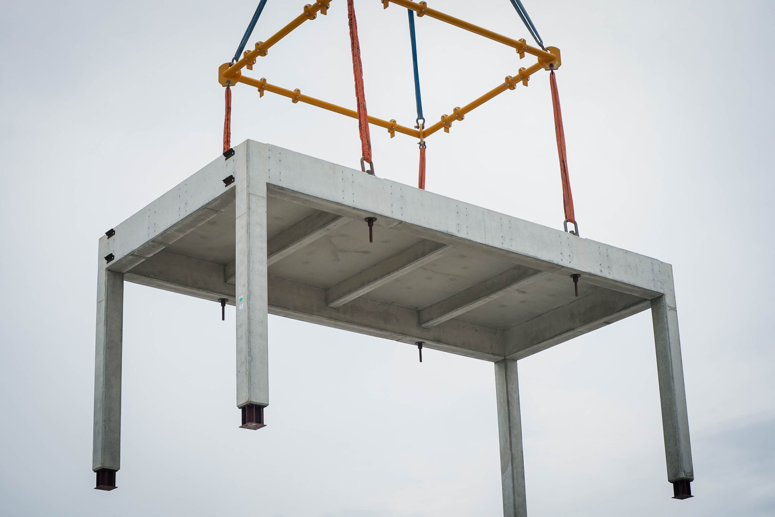 Complete precast structural module suspended from a crane during on-site placement.